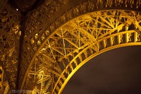 Detail of the arch of the Eiffel Tower at night - Thumbnail